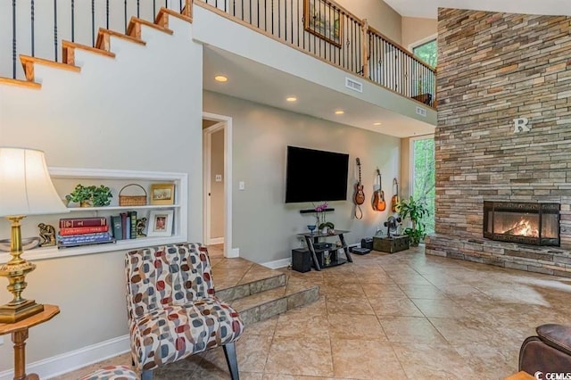 living room featuring a fireplace and a towering ceiling