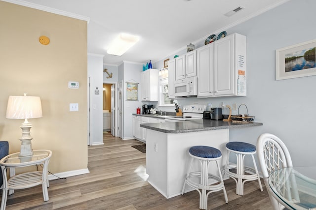 kitchen featuring kitchen peninsula, light wood-type flooring, white appliances, crown molding, and white cabinets