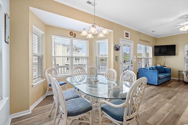 dining space with plenty of natural light, ornamental molding, and light hardwood / wood-style flooring