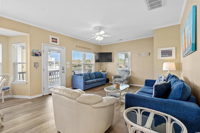 living room with light hardwood / wood-style floors, ceiling fan, and crown molding