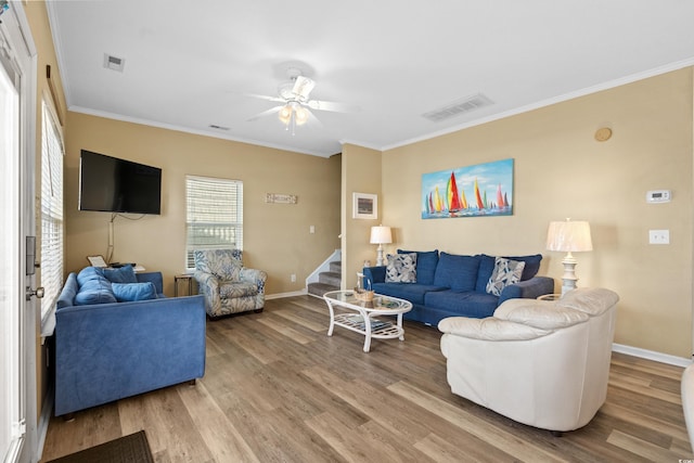 living room with hardwood / wood-style flooring, ceiling fan, and ornamental molding