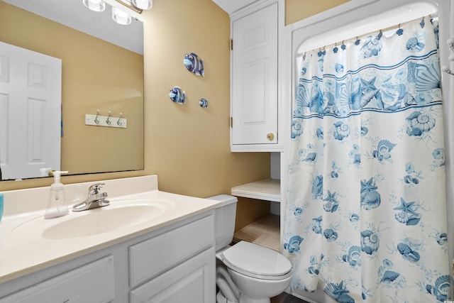 bathroom featuring walk in shower, vanity, and toilet