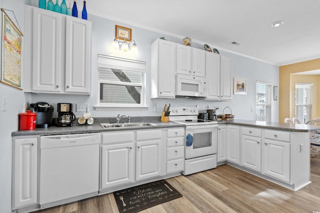 kitchen with kitchen peninsula, white appliances, sink, white cabinets, and light hardwood / wood-style floors