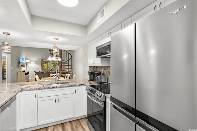 kitchen with white cabinetry, stainless steel appliances, and a wealth of natural light