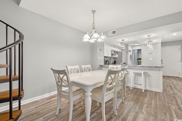 dining area featuring a chandelier and light hardwood / wood-style flooring