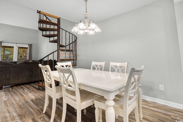 dining room with hardwood / wood-style flooring and an inviting chandelier