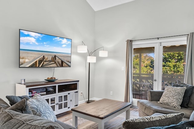 living room with french doors, high vaulted ceiling, and wood-type flooring