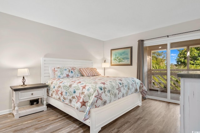 bedroom with hardwood / wood-style floors and access to exterior