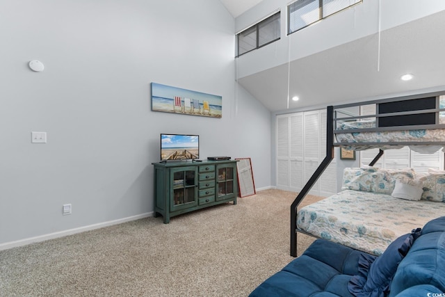 bedroom featuring carpet flooring, a closet, and high vaulted ceiling