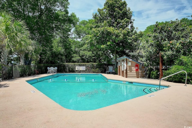 view of swimming pool featuring an outbuilding and a patio area