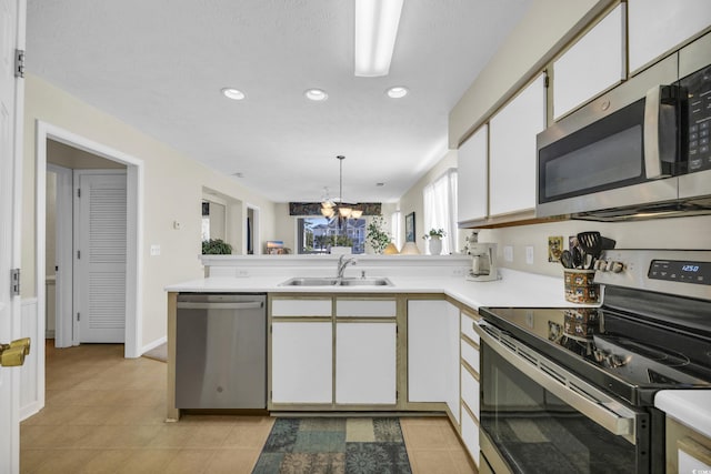 kitchen featuring white cabinetry, sink, an inviting chandelier, pendant lighting, and appliances with stainless steel finishes