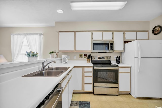 kitchen featuring stainless steel appliances, white cabinetry, and sink