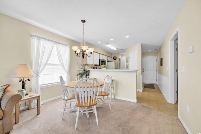 tiled dining room with an inviting chandelier