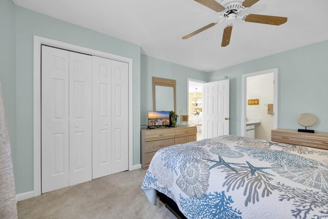 bedroom featuring ceiling fan, light colored carpet, connected bathroom, and a closet