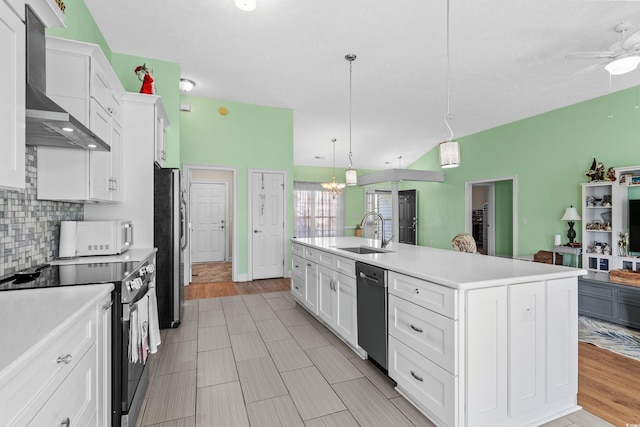 kitchen with light countertops, white cabinetry, wall chimney exhaust hood, stainless steel appliances, and a sink