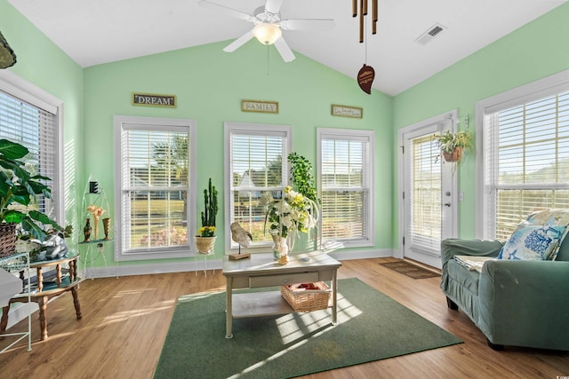 interior space featuring wood finished floors, lofted ceiling, visible vents, and a wealth of natural light