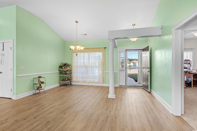 dining room featuring a wealth of natural light, wood finished floors, a chandelier, and vaulted ceiling