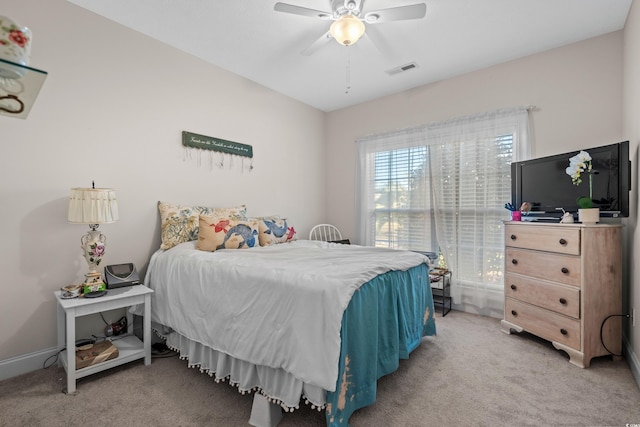 bedroom featuring a barn door, light wood-style flooring, baseboards, and a ceiling fan