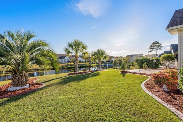 view of yard featuring a residential view and a water view