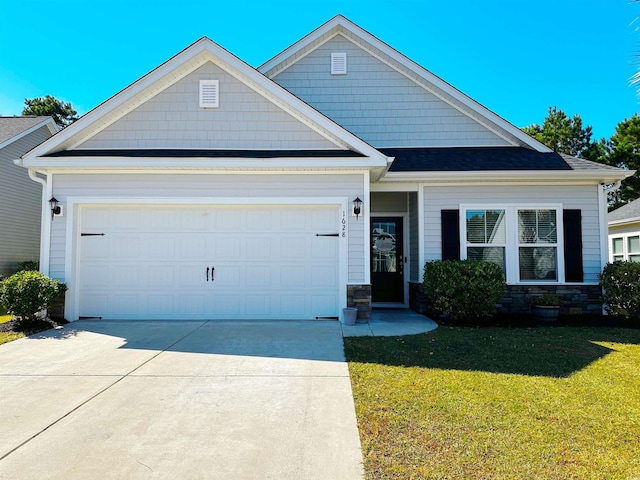 craftsman inspired home with a garage and a front lawn