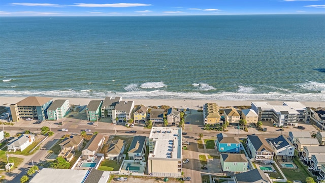 drone / aerial view featuring a beach view and a water view