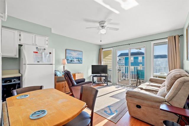 living room with ceiling fan and light hardwood / wood-style flooring