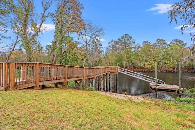 view of dock with a water view and a yard