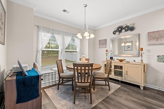 dining room featuring a chandelier, dark wood-type flooring, visible vents, and ornamental molding
