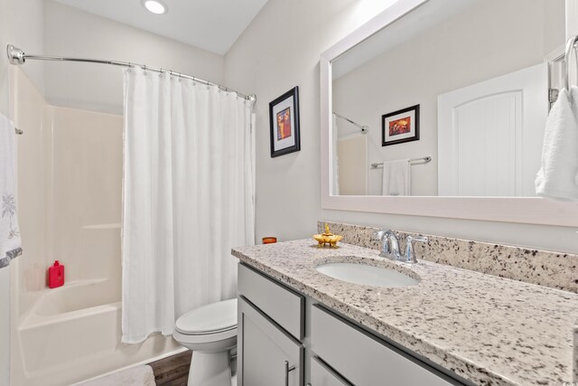 full bath featuring toilet, recessed lighting, shower / bathtub combination with curtain, vanity, and wood finished floors