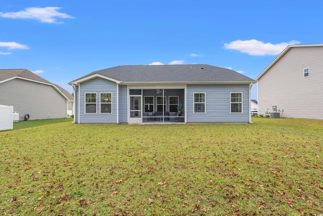 rear view of property featuring a sunroom, cooling unit, and a lawn