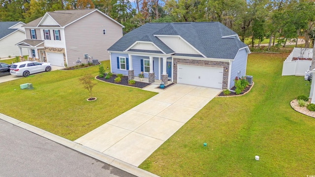 view of front facade featuring a front yard, roof with shingles, a garage, and concrete driveway