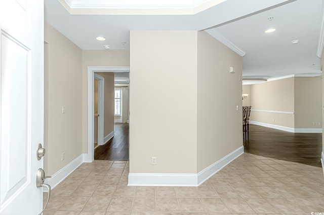 hall featuring light tile patterned floors and crown molding