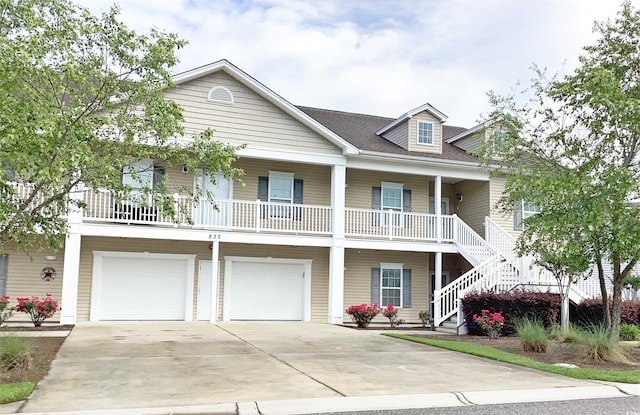 view of front of house with an attached garage, a porch, driveway, and stairway