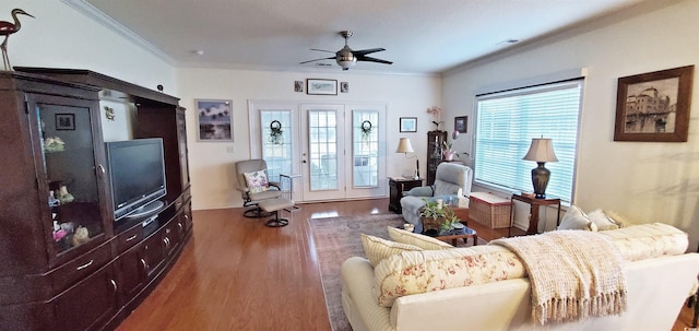 living room with visible vents, ornamental molding, a ceiling fan, and wood finished floors