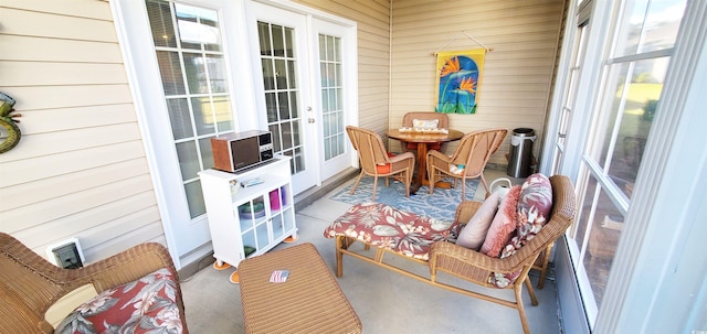 sunroom / solarium with plenty of natural light, outdoor dining area, and french doors