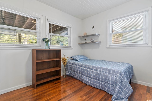 bedroom featuring dark hardwood / wood-style flooring and wooden ceiling