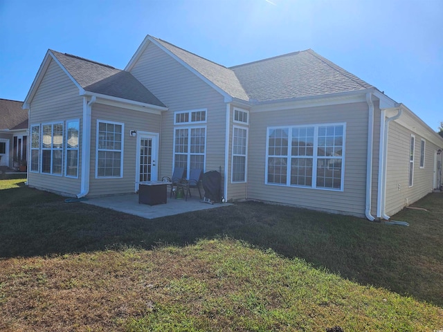 rear view of house with a lawn and a patio