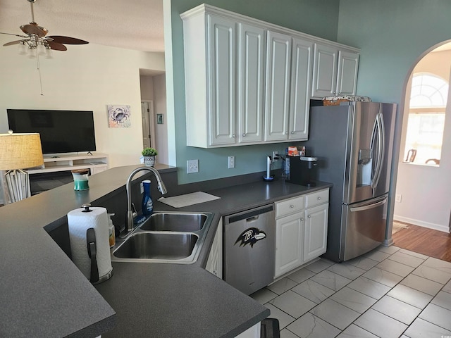 kitchen with white cabinets, ceiling fan, sink, and stainless steel appliances