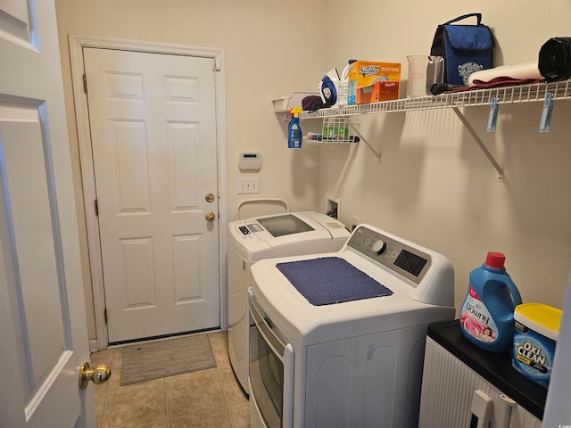 laundry room with washer and dryer and light tile patterned flooring