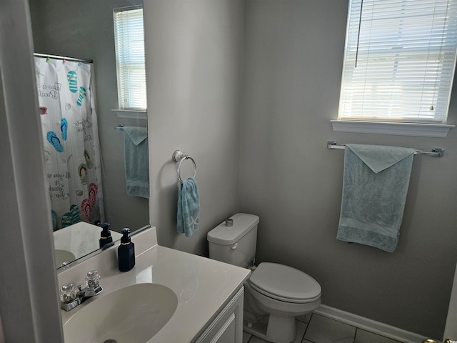 bathroom featuring tile patterned flooring, vanity, a healthy amount of sunlight, and toilet