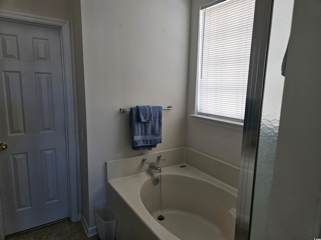 bathroom with tile patterned flooring and a bath