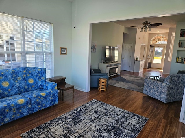 living room featuring plenty of natural light, ceiling fan, and dark hardwood / wood-style flooring