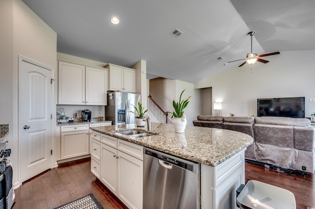 kitchen with dark hardwood / wood-style flooring, stainless steel appliances, vaulted ceiling, a kitchen island with sink, and sink