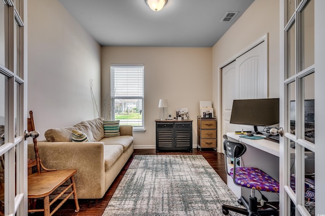 home office with dark hardwood / wood-style floors and french doors