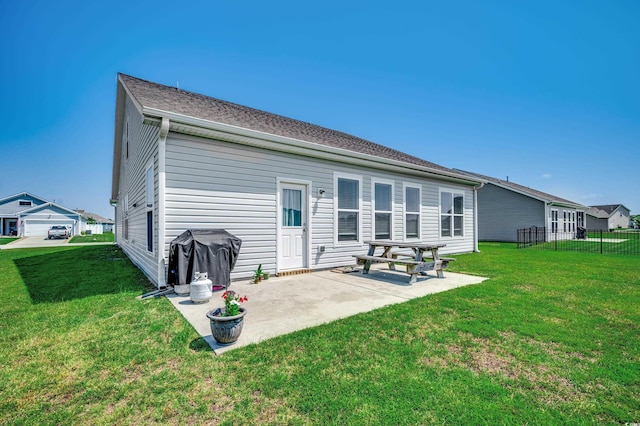 back of property with a yard and a patio