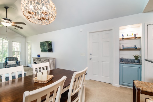 dining space featuring light carpet, ceiling fan, and lofted ceiling