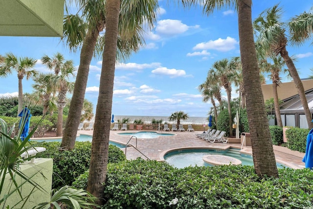 view of pool with a jacuzzi and a patio