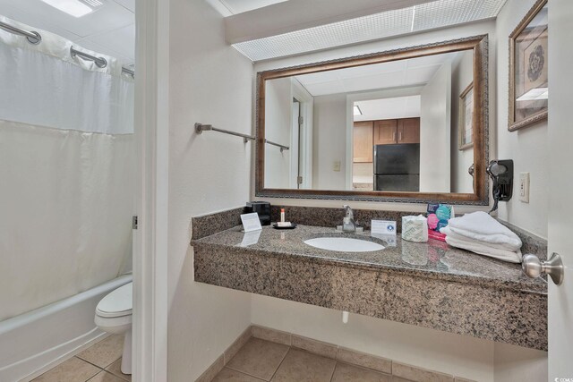 full bathroom featuring tile patterned flooring, toilet, shower / bathtub combination with curtain, and sink