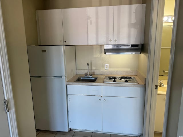 kitchen with white refrigerator, sink, range hood, white cabinetry, and stainless steel gas cooktop