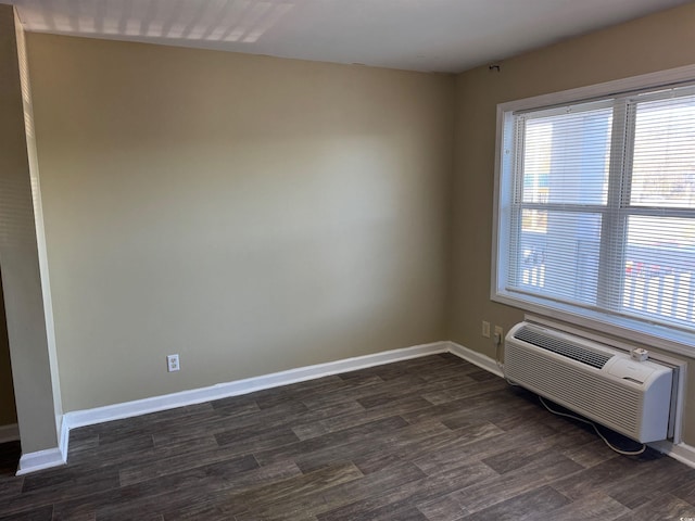 empty room with dark hardwood / wood-style floors and a wall mounted AC